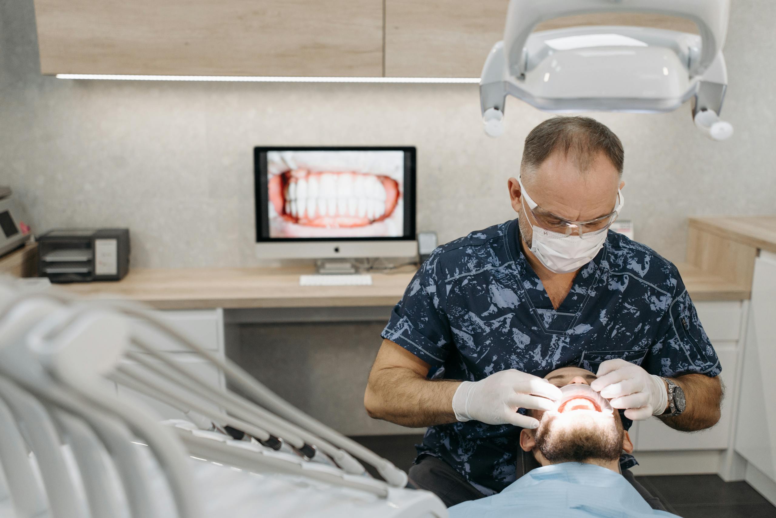 Dentist in surgical mask performing a dental check-up on a patient in a modern clinic.